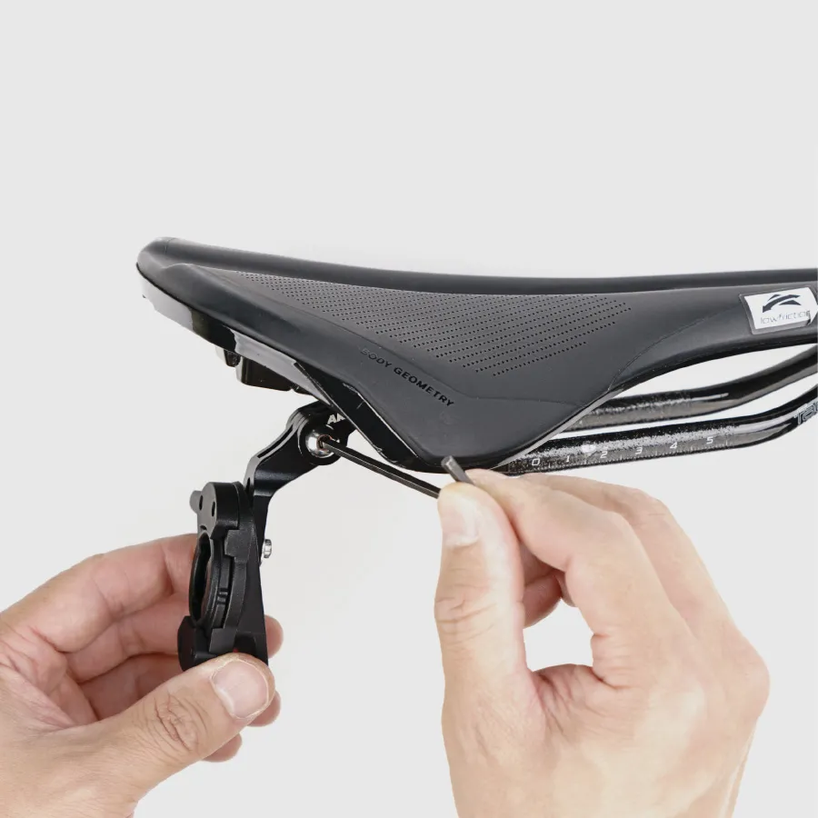 Hands adjusting Akro mounts on bicycle saddle